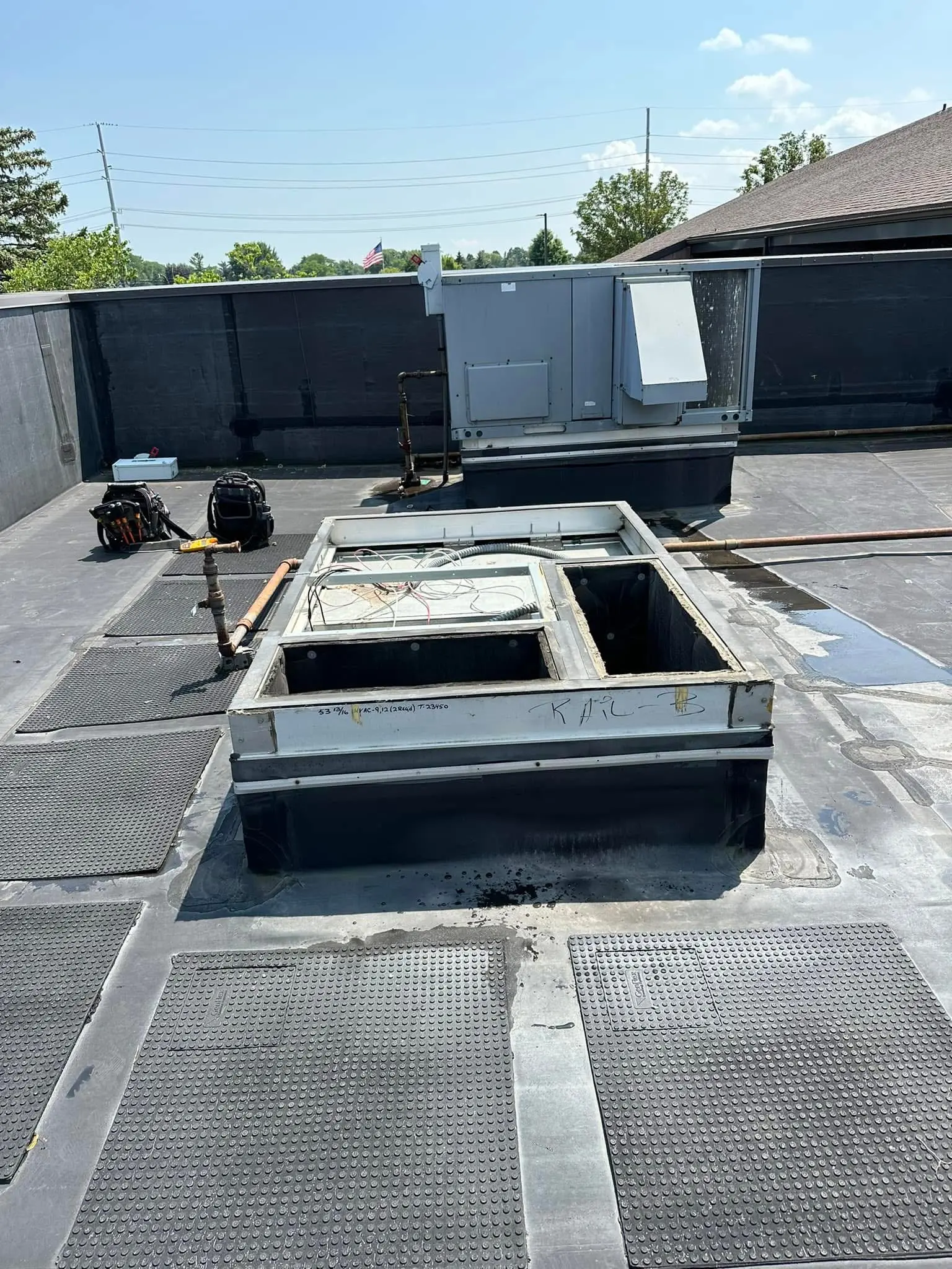Rooftop HVAC unit near open roof hatch
