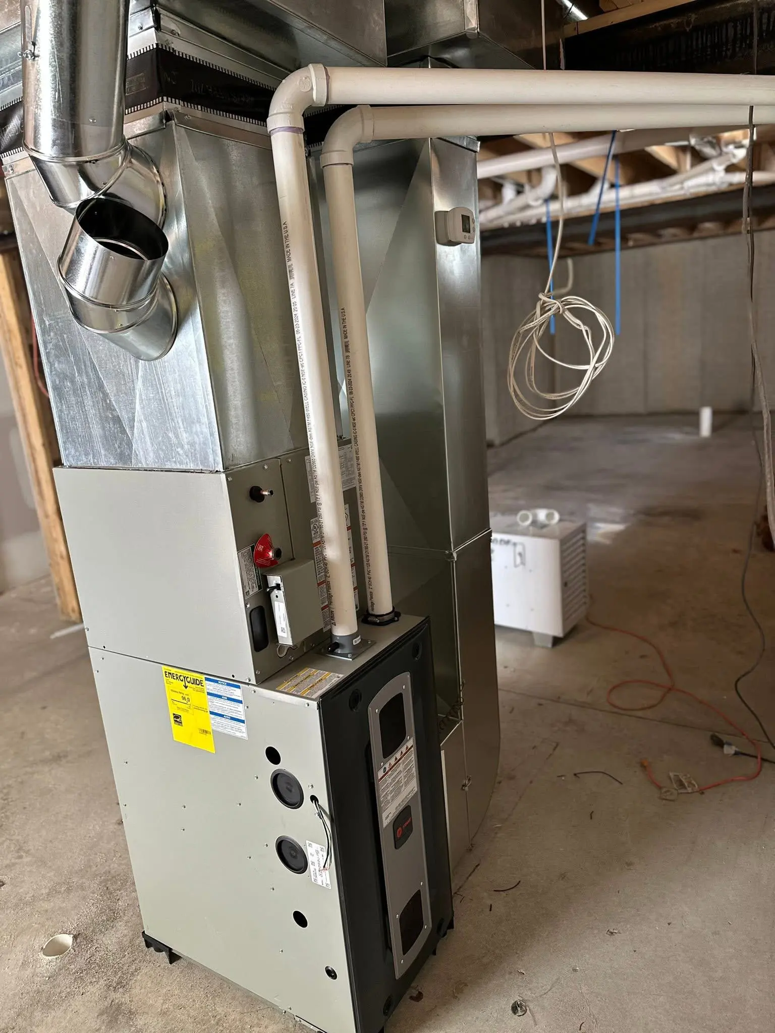 Basement HVAC furnace with ductwork and pipes