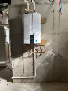 Tankless water heater mounted on concrete basement wall