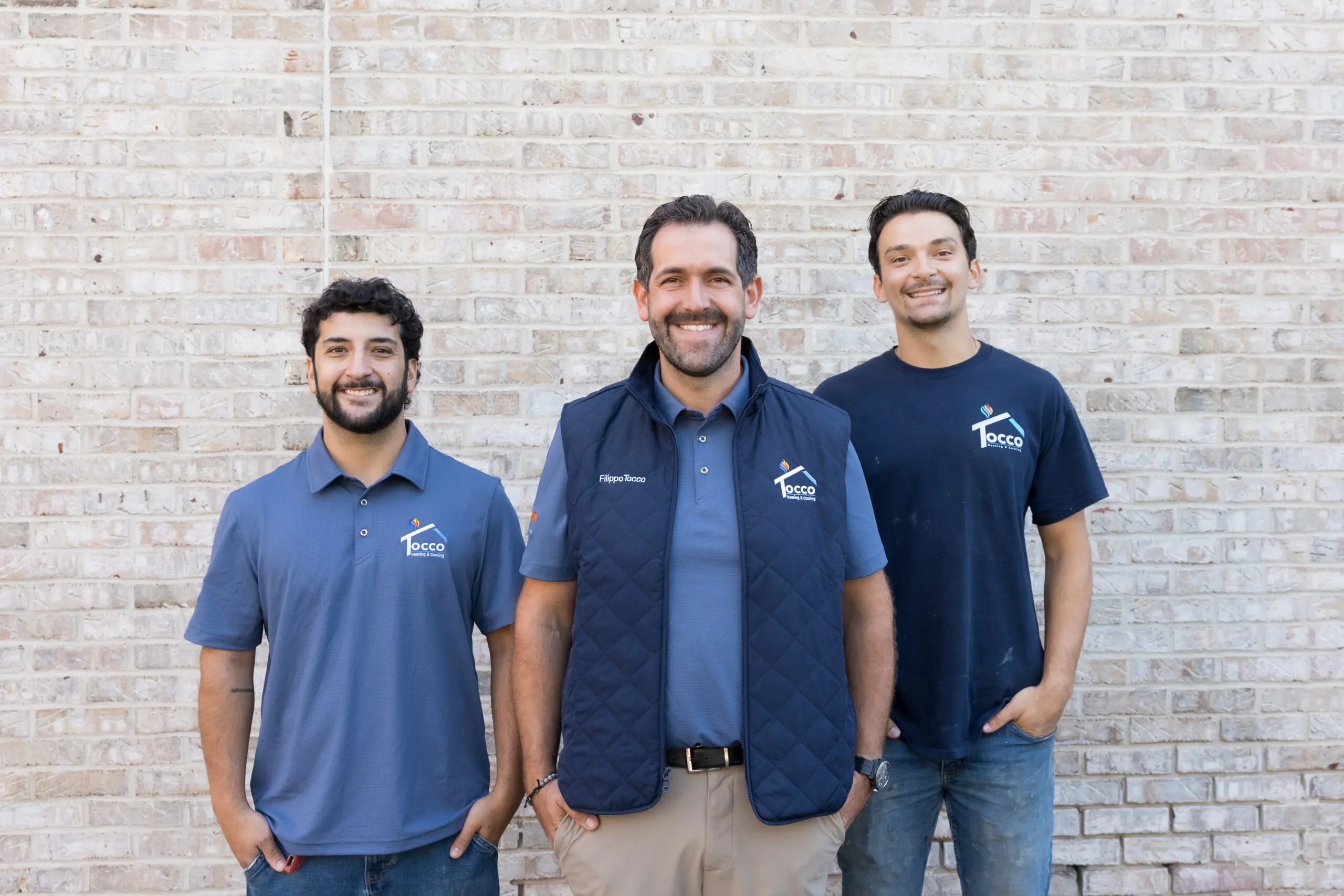 Three smiling men in company shirts
