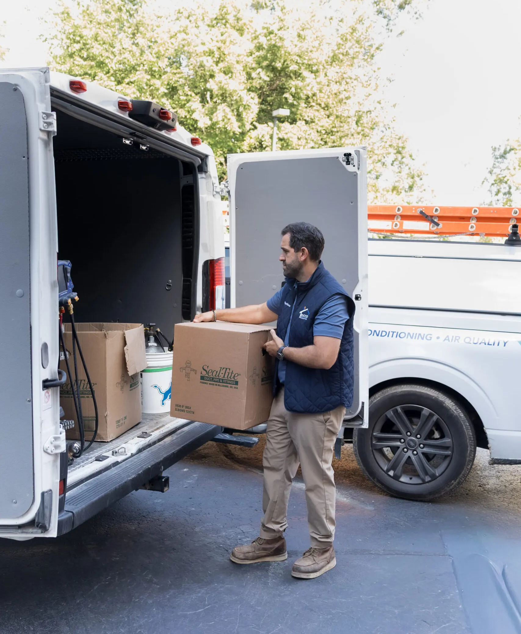 HVAC technician loading equipment into service van